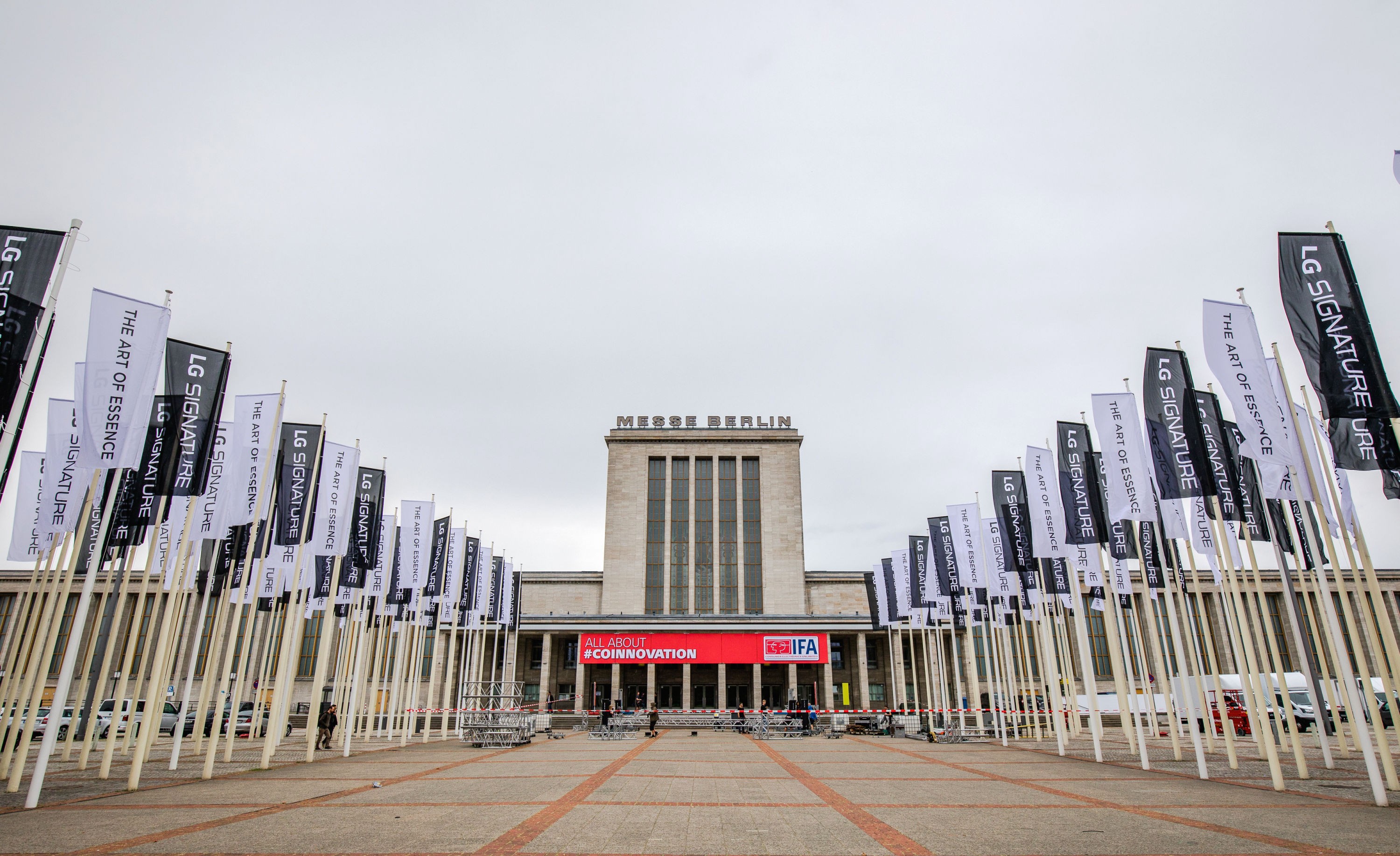 Front view of Messegelände Berlin ExpoCenter City with promotional flags of the LG SIGNATURE brand and its brand theme “The Art of Essence” flying in front