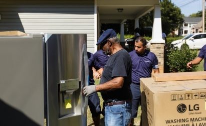 A group of volunteers check and assemble parts of LG-donated home appliances.