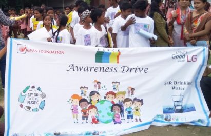A group photo of participants of the LG Eco Agents of Change campaign holding a banner with an illustration that promotes the importance of young people when it comes to conserving the environment.