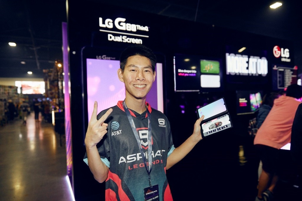 A contender poses while holding the LG G8X ThinQ with Dual Screen in front of the smartphone and dual screen’s display zone.
