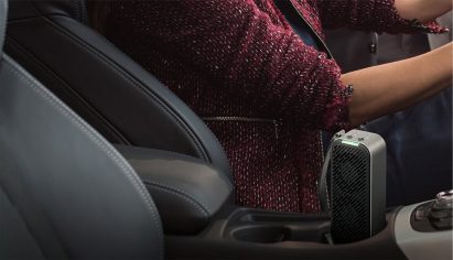 LG PuriCare Mini standing in the cup holder between driver and front passenger seat