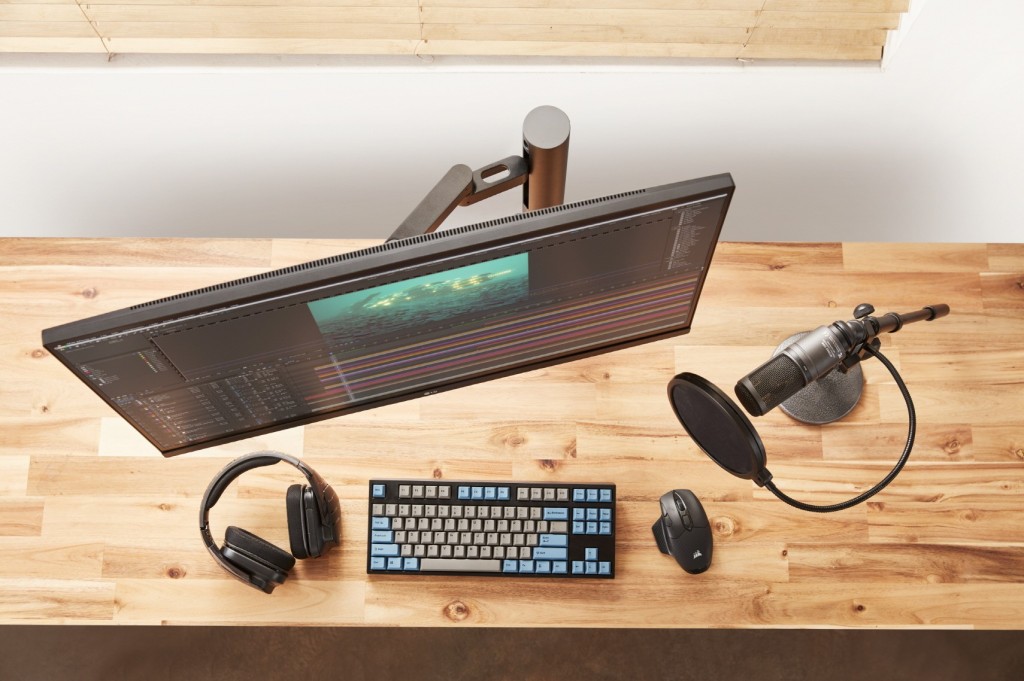 High view of LG UltraFine Monitor 32UN880 completing a desk setup comprising a keyboard, mouse, professional microphone and headphones