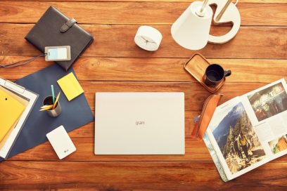 A birds-eye-view of LG gram model 15Z90N laid flat on a wide desk with other handy utensils