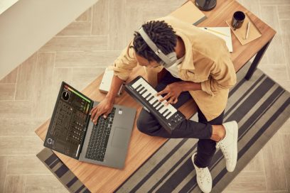 A man using his LG gram model 17Z90N with a piano keyboard to work on his music while sat on a bench, all without the need for a charger