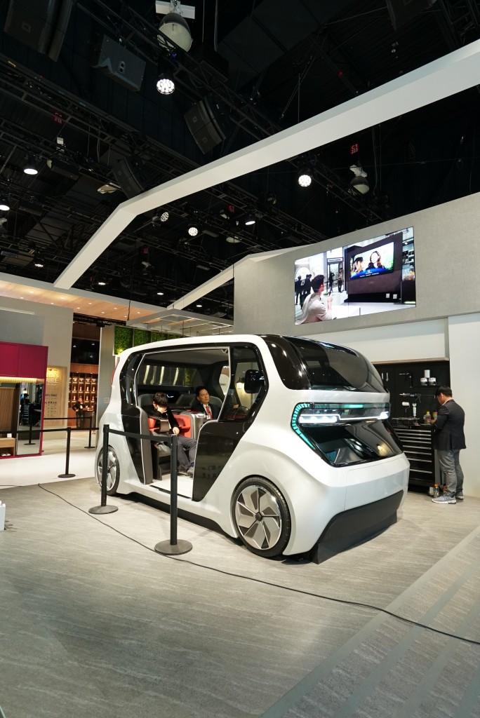 A front side view of LG’s Connected Car concept with two people sitting inside, which was unveiled at CES 2020 to highlight the future of cars via LG ThinQ