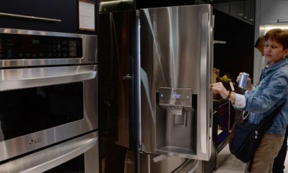 A visitor to the LG booth opens one of the company’s advanced refrigerators while looking toward the innovative oven range which is on display to its side