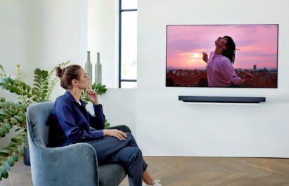A woman watches a movie on LG’s Wallpaper series OLED TV model WX that boasts immersive picture quality