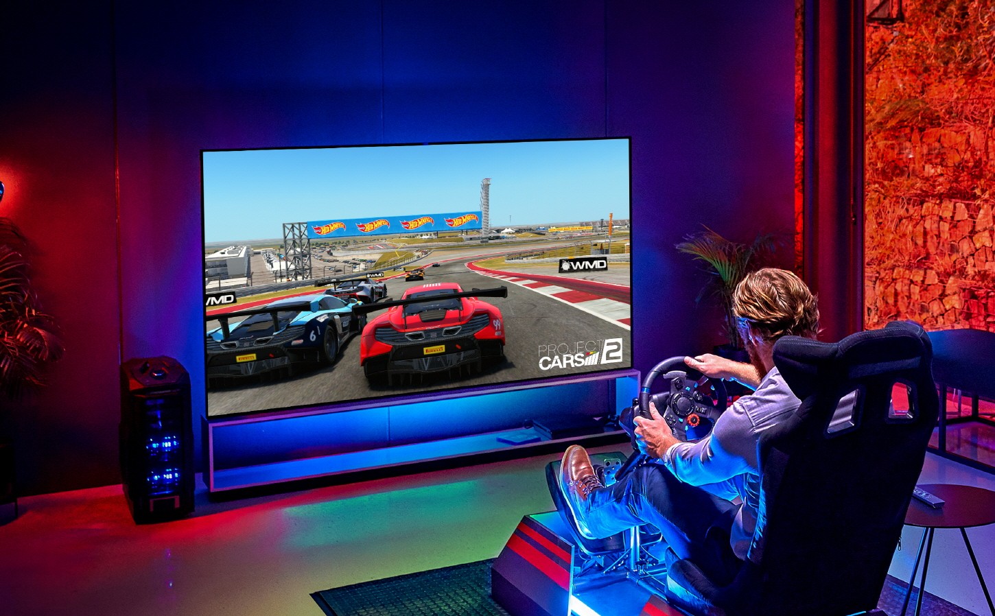 A man enjoys an immersive gaming experience while playing a racing game on the LG 8K OLED TV ZX