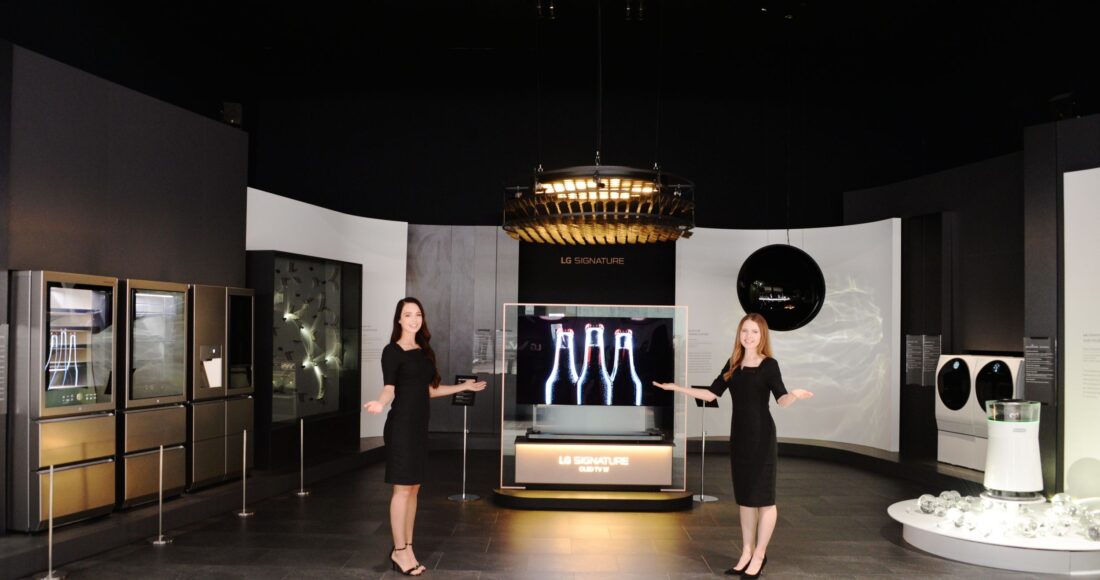 Two female models point at the prototypes of the LG SIGNATURE lineup at the display zone of CES 2019.