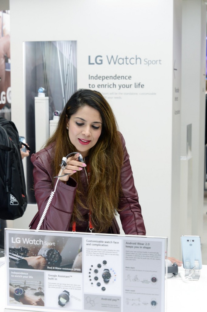 A woman tries out a sample of the LG Watch Sport smart watch at LG's MWC 2017 booth.