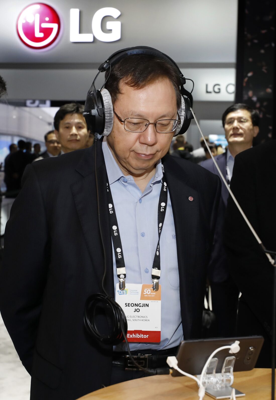 Jo Seong-jin, Vice Chairman and Chief Executive of LG Electronics tests the sound quality of LG's new smartphone via headphones at the company's CES booth.