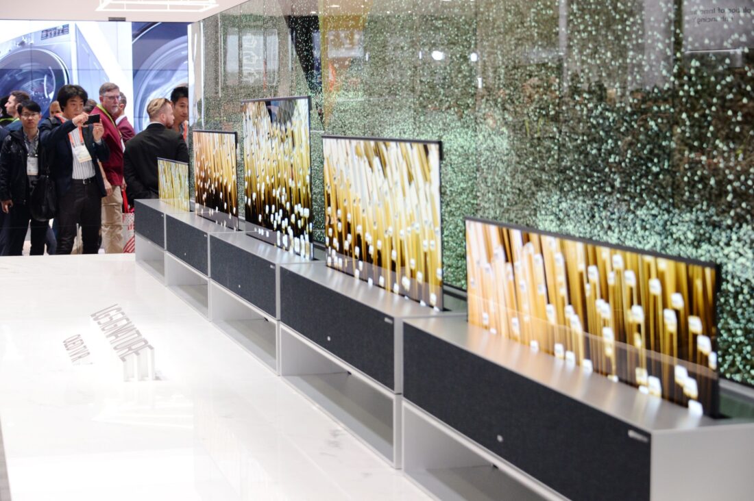 Closer view of LG SIGNATURE OLED TV R display zone with CES visitors viewing the display and taking pictures