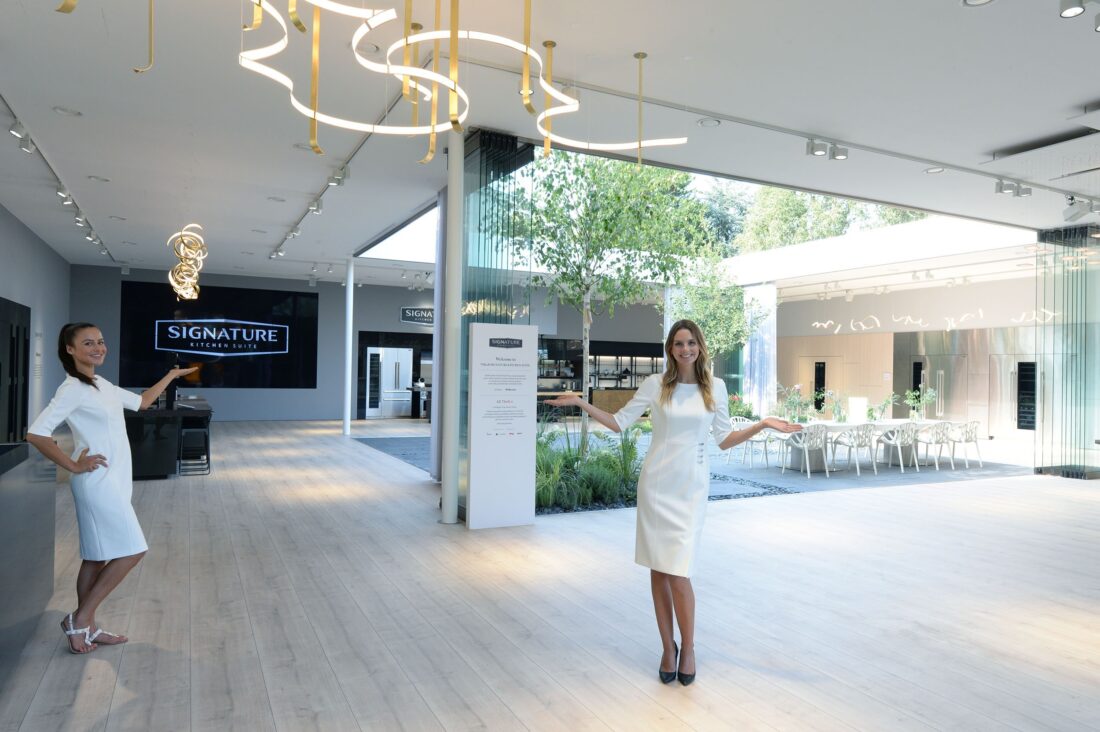 Another wide-angle view of the LG Signature Kitchen Suite display zone, two models are pointing the way inside