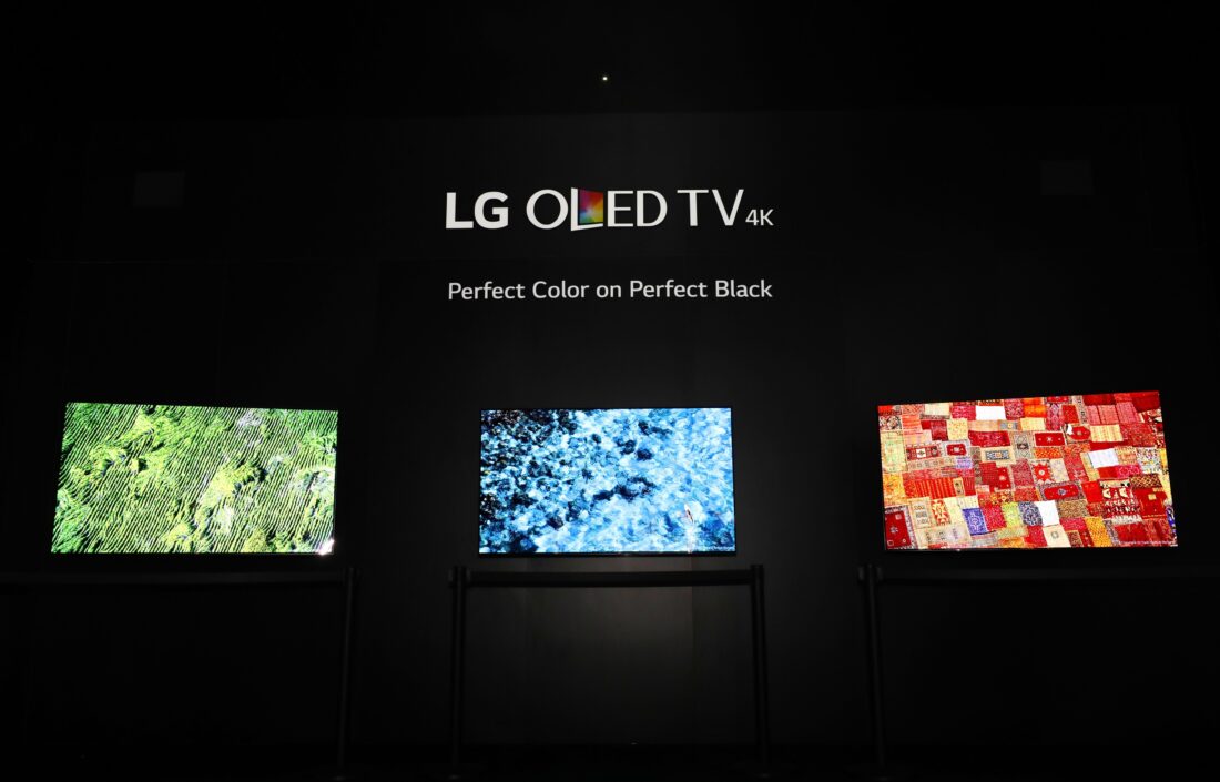 Three LG OLED TV models demonstrate the perfect colors and perfect black in a dark room at LG's CES 2017 booth.