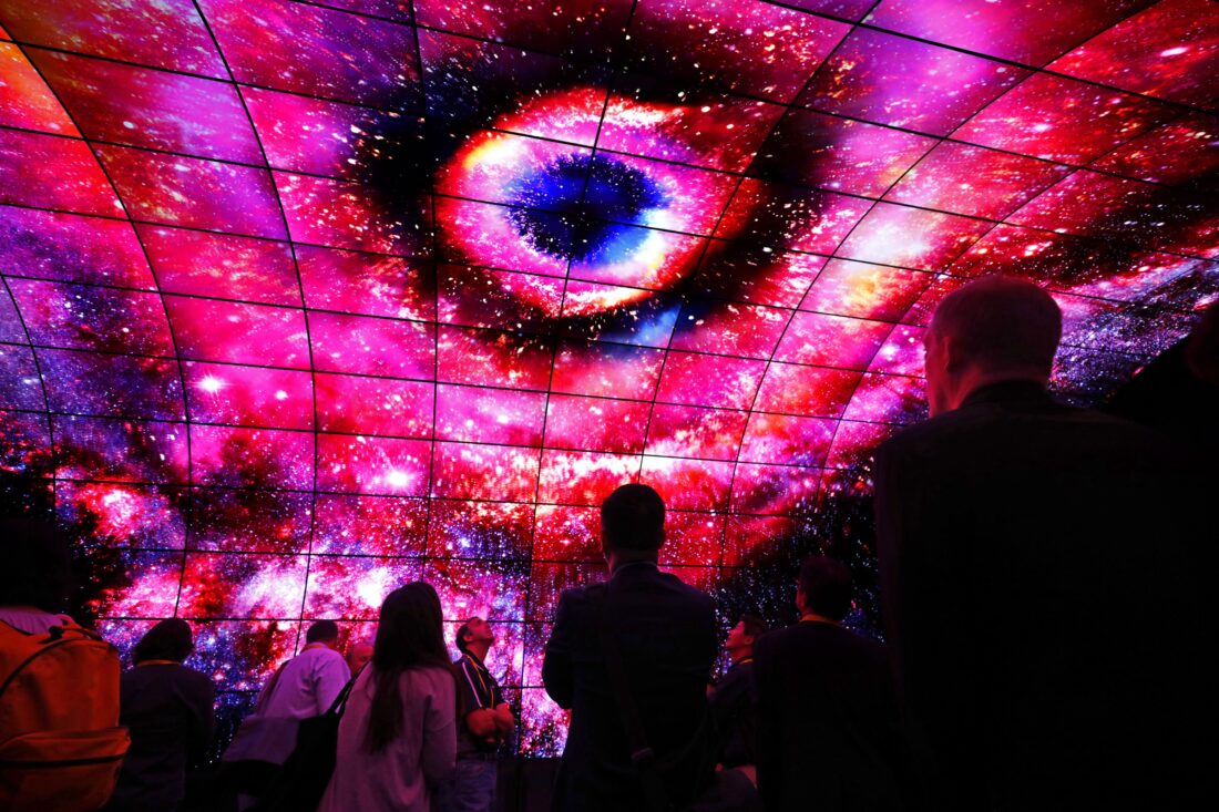 Visitors look up at the displays of the LG OLED Tunnel and admire the incredible picture quality of OLED at LG's CES 2017 booth.
