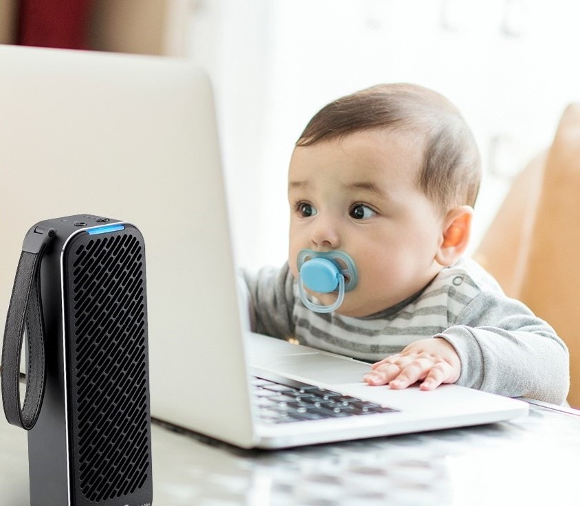 An adorable baby stares at a laptop monitor as the LG PuriCare Mini Air Purifier works in the foreground