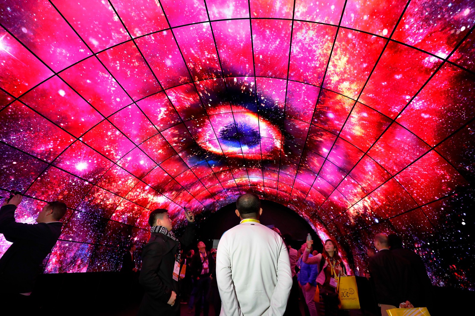Visitors look up at the OLED screens of the LG OLED Tunnel at LG's CES 2017 booth