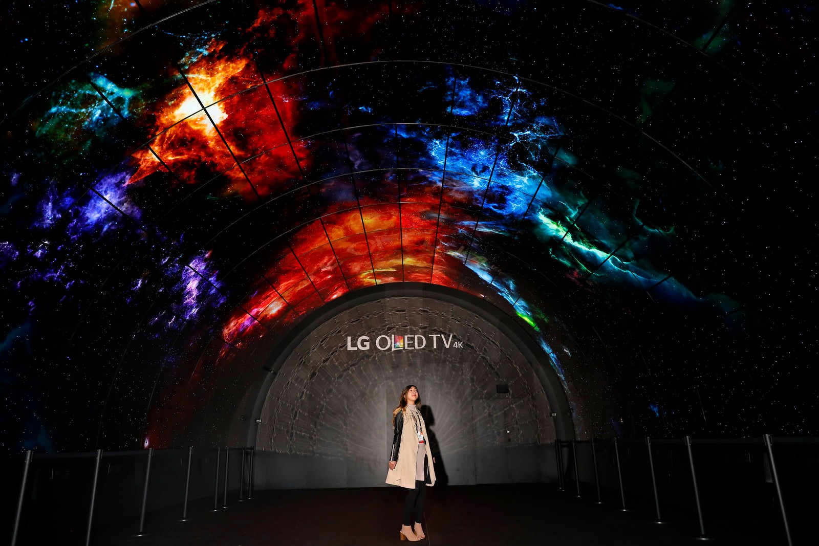A woman stands under the LG OLED Tunnel which is set up at the entrance of LG's CES 2017 booth.