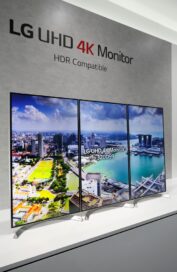 A close view of three LG UHD 4K monitors set up side by side in a vertical position at LG's CES 2017 booth