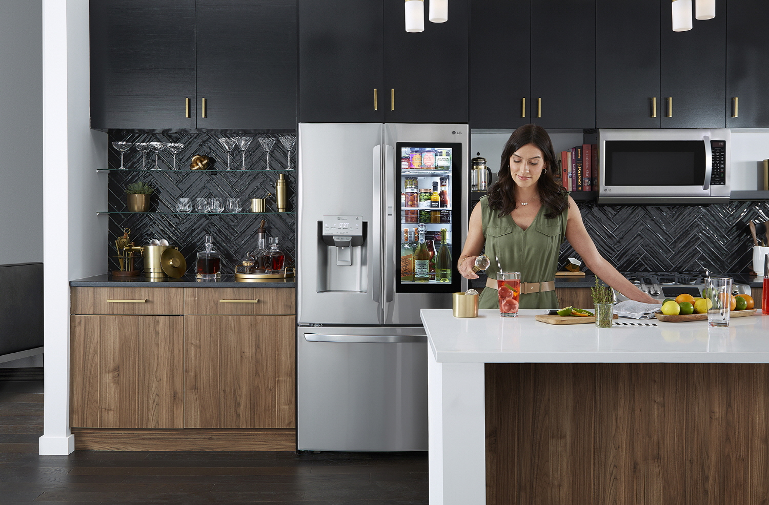 A woman preparing a beverage with Craft Ice™ in a kitchen with LG InstaView Door-in-Door™ refrigerator