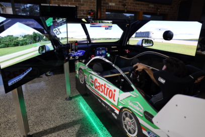 A complete view from the back of someone using the immersive racing simulator