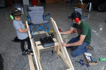 Rick Kelly and his son in the act of building their at-home racing simulator