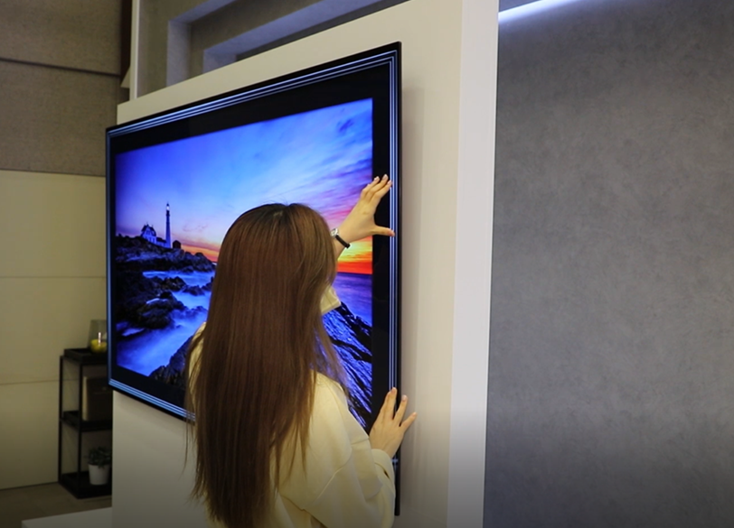 A woman takes a closer look at the thinness of the LG GX Gallery series TV