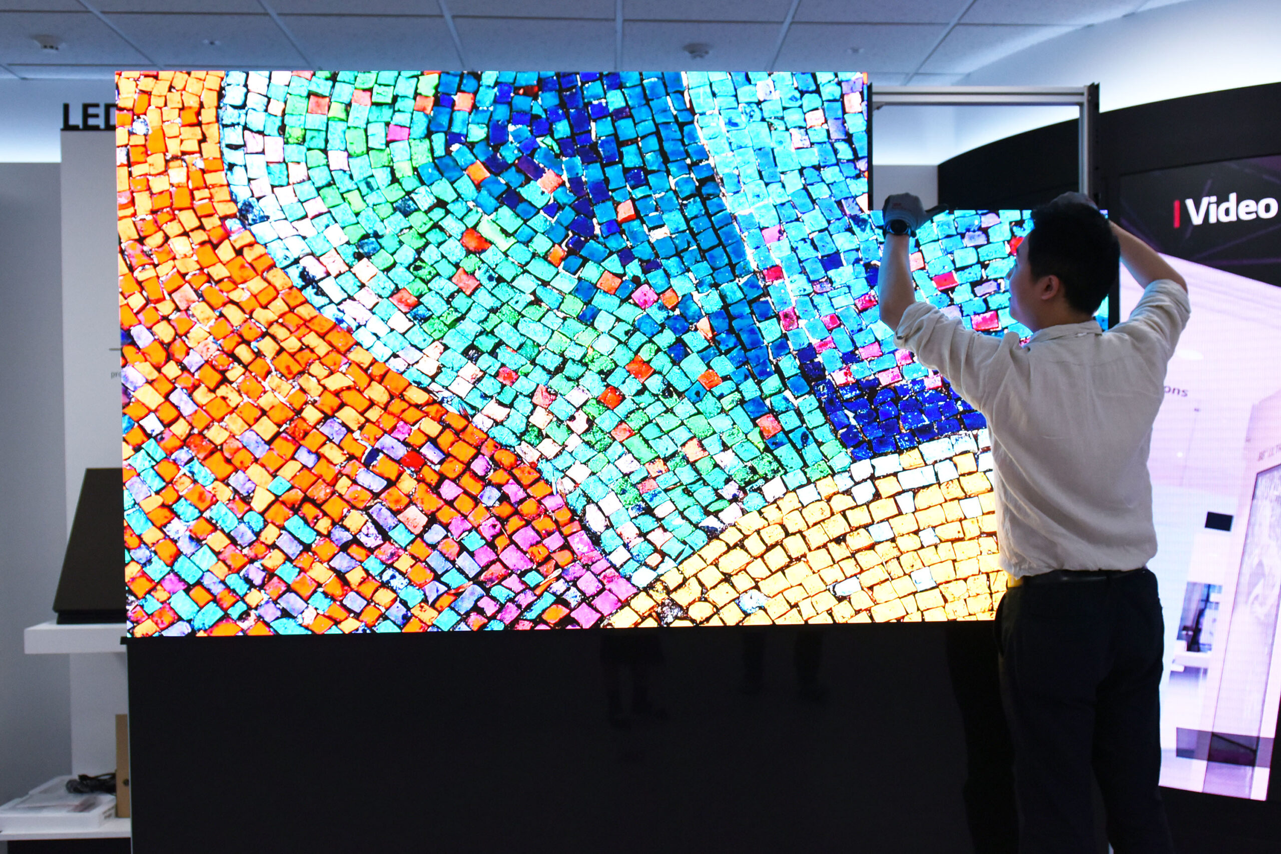 A man installing the LG LED Signage (LSAA) demonstrates how perfectly and easily each panel fits together to make a vibrant, high-quality large display