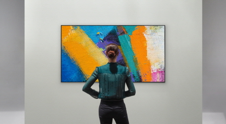 A woman admiring the LG GX Gallery series TV