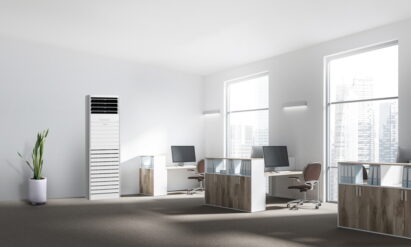 LG's commercial air purifier in an office with a flowerpot on the left and three office desks on the right