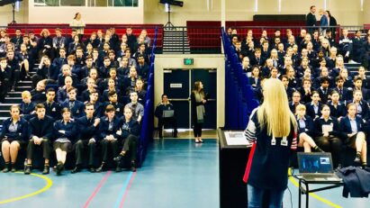 Melissa McGuinness stands in front of school children during assembly to talk to them about road safety