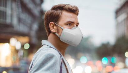 A man on a street wearing LG PuriCare wearable Air Purifier