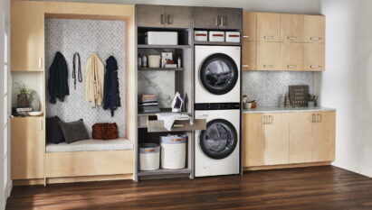 The white LG WashTower fitted inside a modern room with wooden furnishings and next to a space designed for ironing and storing dirty laundry