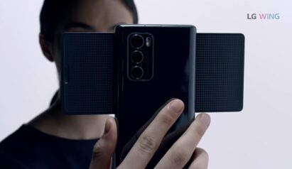 A person holds LG WING in Swivel Mode with the three rear camera lenses clearly seen
