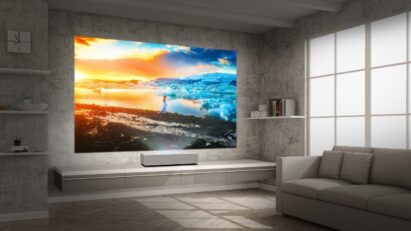 LG CineBeam stands closely to the wall of a modern living room yet still projects a large high-res image of a majestic glacier during a sunset