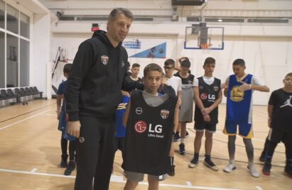 Participants of the LG Skills & Drills Contest watch on as one of the kids holds up an LG-branded jersey next to Greek basketball legend Thodoris Papaloukas