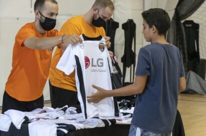 A member of staff giving out LG-sponsored uniforms to participants during the event