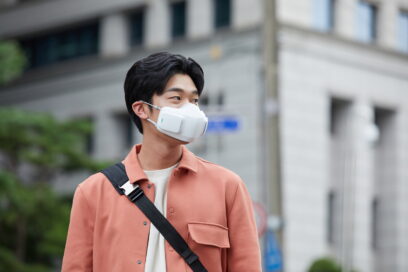 A man on a street wearing LG PuriCare™ wearable Air Purifier