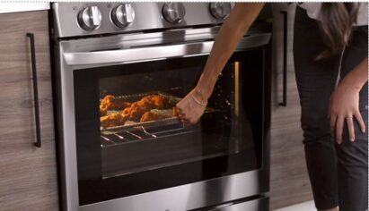 A woman knocks on the door of her LG smart oven via InstaView to check on her meal’s cooking progression