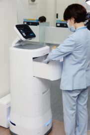 A medical worker taking equipment from one of LG CLOi ServeBot's useful drawers