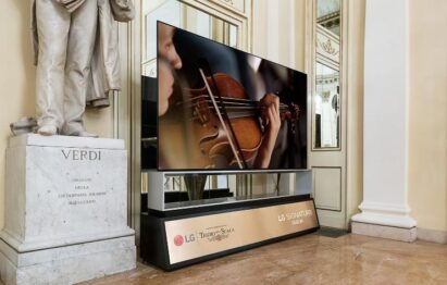 The LG SIGNATURE OLED 8K TV standing next to a statue of Giuseppe Verdi in La Scala displays a musician playing the violin during Rigoletto