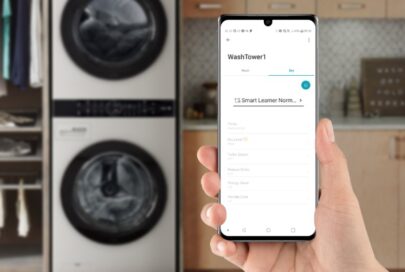 A close-up of someone using the LG ThinQ app to control and monitor the LG WashTower shown in the background