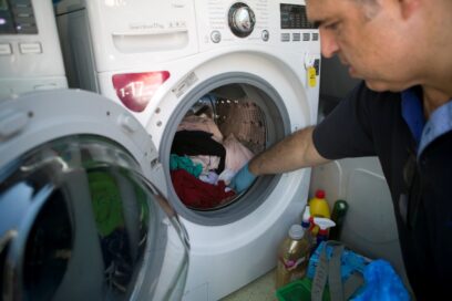 A man from Ithaca using an LG washing machine donated by LG Greece.