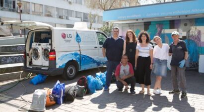 Members of Ithaca, who are making a big difference to those in need, pose next to their van that holds LG washers and dryers with the support of LG Greece.