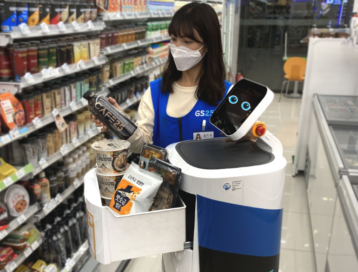 LG CLOi ServeBot working at a convenience store at LG Sciencepark as an employee fills it up with snacks for delivery.