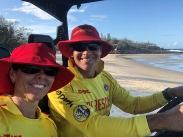 Scott Collins and a fellow member of Surf Life Saving Australia, the nation’s leading non-profit organization for coastal water safety, in full uniform while operating an emergency vehicle.