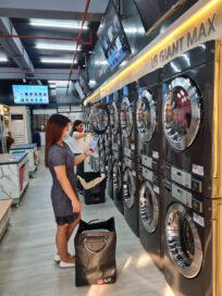 A woman is checking Laundry Lounge app in front of the laundry solution.
