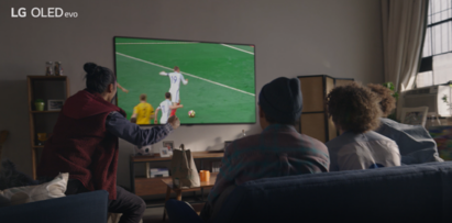 Four friends enjoying a game of football on LG OLED TV