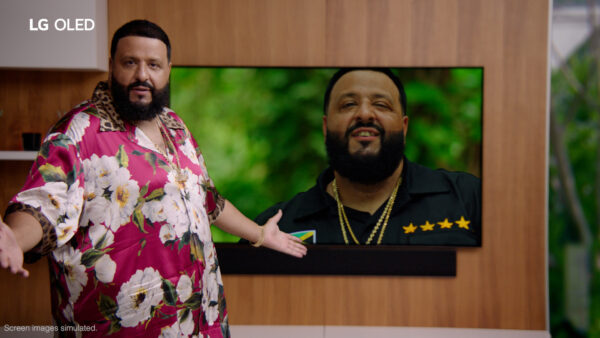 DJ Khaled posing with LG OLED TV as it displays one of his popular music videos