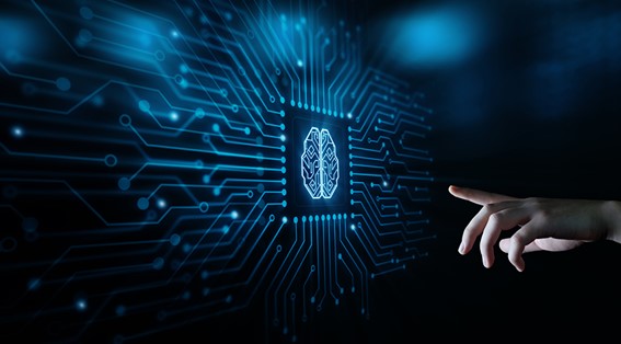 A hand pointing at a semiconductor inscribed with the image of a brain in the middle of a circuit 